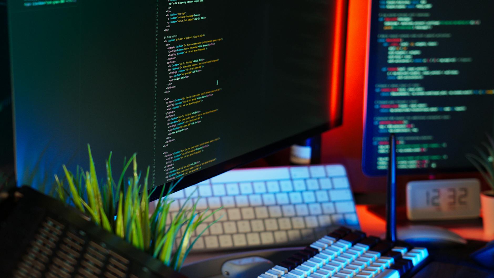 Dark developer workstation with multiple monitors showing code and terminal interfaces